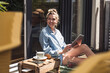 © Westend61 - Woman relaxing on balcony with digital tablet in hands