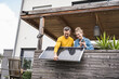 © Westend61 - Couple installing solar panel on wooden balcony