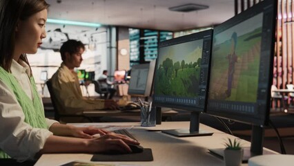 Fototapete - Asian Woman Using Desktop Computer And Designing In 3D modelling Software Unique World And Characters For Survival Video Game In Diverse Office. Female Game Developer Creating Immersive Gameplay.