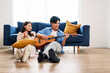 © artitwpd - Attractive new marriage man and woman sit on the floor enjoy singing and playing guitar in the living room at the new home. A family spends quality time together after moving into a new home.