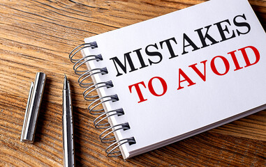 Poster - MISTAKES TO AVOID text on notebook with pen on wooden background