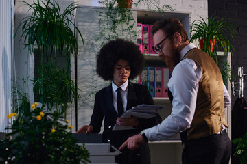 Wall Mural - bearded businessman showing african american secretary with documents how to use copier in office