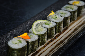 Wall Mural - Fresh sushi rolls with lime slice and flower