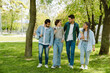 © Drobot Dean - Four young students walking together in park