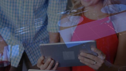 Poster - Animation of data processing against caucasian man and woman discussing over a tablet at office