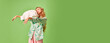 Banner. Poster.Portrait of sleepy woman in pajama holding pillow in hands, going to bed like zombie against on pastel green background.