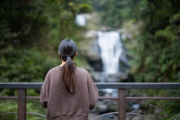 Poster - Woman look at the beautiful waterfall