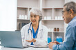 © Phushutter - Elderly patient asian people attentively listening to mature doctor, receiving valuable health advice and discussing comprehensive health results in caring medical environment. Health Consultation