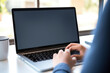 © Anoo - Photo of a person working on a laptop at a desk