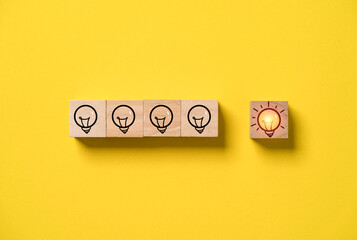 Fototapete - Glowing lightbulb separate from shutdown lightbulbs on yellow background for disruption of problem solving idea and creative innovation concept.