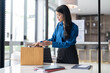 © Charlie's - Quit Job asian business woman sending resignation letter and packing Stuff Resign Depress or carrying business cardboard box in office. Change of job or fired from company