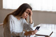 © fizkes - Angry young woman looking at phone screen, reading bad news in email or social network message, unpaid debt or spam, annoyed girl having problem with broken or discharged smartphone
