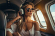 Beautiful young woman listening to music through the headphones in a private jet