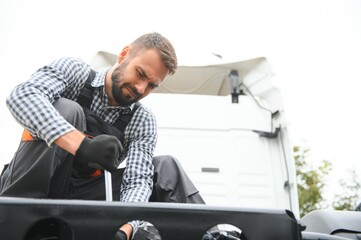 Wall Mural - Man in uniform. Truck repair. Car malfunction.