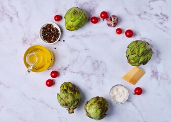 Wall Mural - Culinary background with artichokes, seasonings, cheese, garlic and olive oil on a light background with space for text.