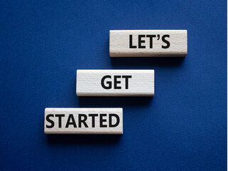 Wall Mural - lets get started symbol. concept words lets get started on wooden blocks. beautiful deep blue backgr