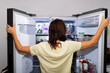 © Patricia - woman with her back looking inside the refrigerator out of craving or famine. lack of food