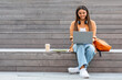© Prostock-studio - Cheerful young woman student working on project, using laptop outdoors