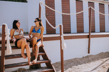 Wall Mural - Smiling young women in bikini enjoying vacation on the beach