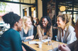 © Jasmina - Happy smiling female friends sitting in a café laughing and talking during a lunch break