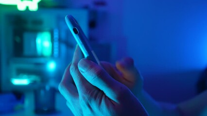 Side view of unrecognizable young man holding cellphone in hands, scrolling personal page in social network, looking at photos, reading news in media, using dating application, web surfing information