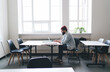 © BullRun - Man in red hat working on laptop at desk in office