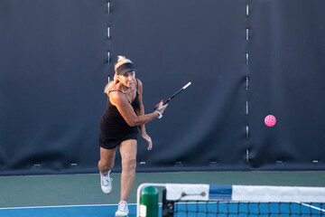 Female Pickleball Player Returning Serve