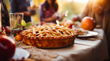 Thanksgiving Family Dinner. Traditional Apple Pie And Vegan Meal Close Up, With Blurred Happy People Around The Table Celebrating The Holiday. Togetherness With Family.