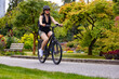 Fit Caucasian Woman riding an Electric Bicycle on a trail in Stanley Park, Downtown Vancouver, British Columbia, Canada.