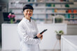 © Zamrznuti tonovi - A Japanese medical assistant is standing in a pharmacy with a tablet in her hands.