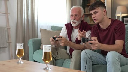 Wall Mural - teenager male and his grandfather senior man play console video game