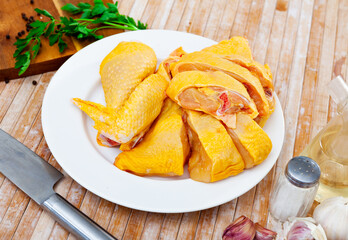 Poster - Pieces of unprepared chicken on table. Cooking dinner on table at home.