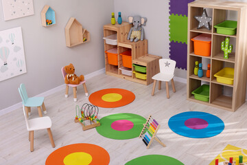 Sticker - Child`s playroom with different toys and furniture, above view. Cozy kindergarten interior