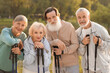 © New Africa - Senior men and women with Nordic walking poles outdoors