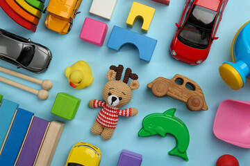 Wall Mural - Different children's toys on light blue background, flat lay