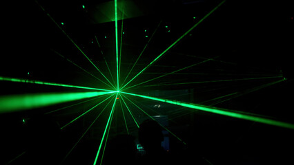 Poster - Club youth party. Clip. Green laser beams on the backlight next to the DJ and dancing people.