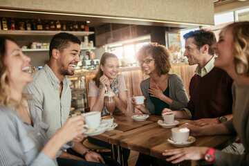 young and diverse group of people having coffee together at a cafe in the city