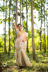 Beautiful Indian bride in traditional wedding clothes in forest