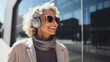 Senior woman wearing headphone wireless listen music and happy walking in the city modern