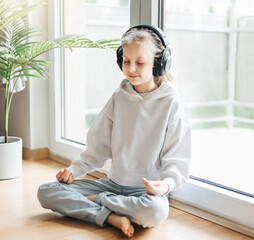 Wall Mural - Cute little girl listening to music in headphones