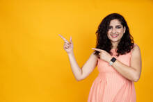 People Emotions, Lifestyle And Fashion Concept. Enthusiastic Attractive Asian Indian Girl Pointing Right, Standing Yellow Background