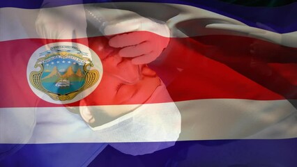 Wall Mural - Animation of waving costa rica flag over doctor placing oxygen mask on a female patient at hospital