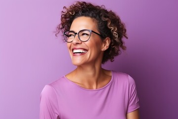 Wall Mural - Portrait of a beautiful young african american woman with curly hair and glasses smiling against purple background