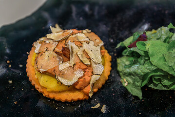 deconstructed foie gras and truffle apple tart tatin with a salad at a french restaurant in the carr