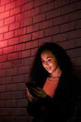 Poster - Phone, city night wall and woman typing, search internet or check mobile info, app or contact social media user. Red neon light, communication and person networking, relax or research cellphone news