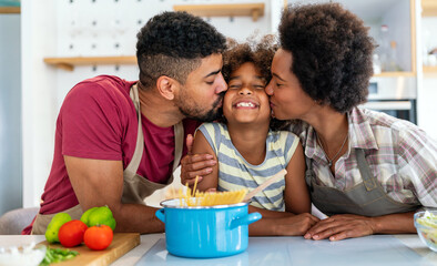 Wall Mural - Overjoyed young african american family with kid have fun cooking at home together,