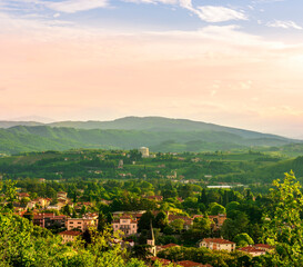 Wall Mural - travel summer view from hill to a nice european town with amazing buildings, green hills and mountains with amazing cloudy evening sky on background