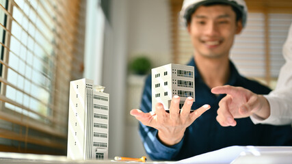 Architects team working with architectural model model of residential at meeting. Construction, property and real estate