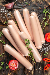 Wall Mural - Fresh sausages on a wooden board. vertical image. top view. place for text