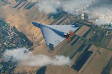 Military kamikaze drone Shahed flying in the clouds over rural landscape, Iranian combat drone in the sky, war in Ukraine, 3d render.
